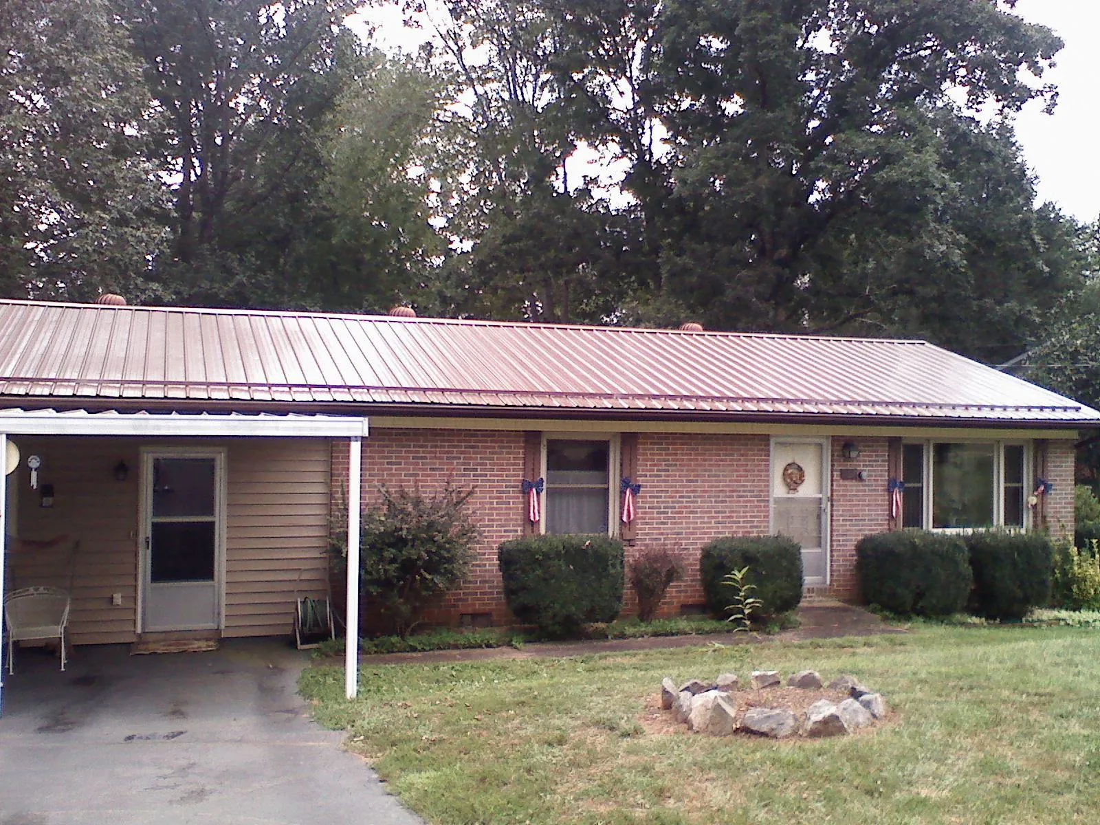 Bronze metal roof and carport on a brick ranch home — Roof Repair work by our crew in Saint Regis