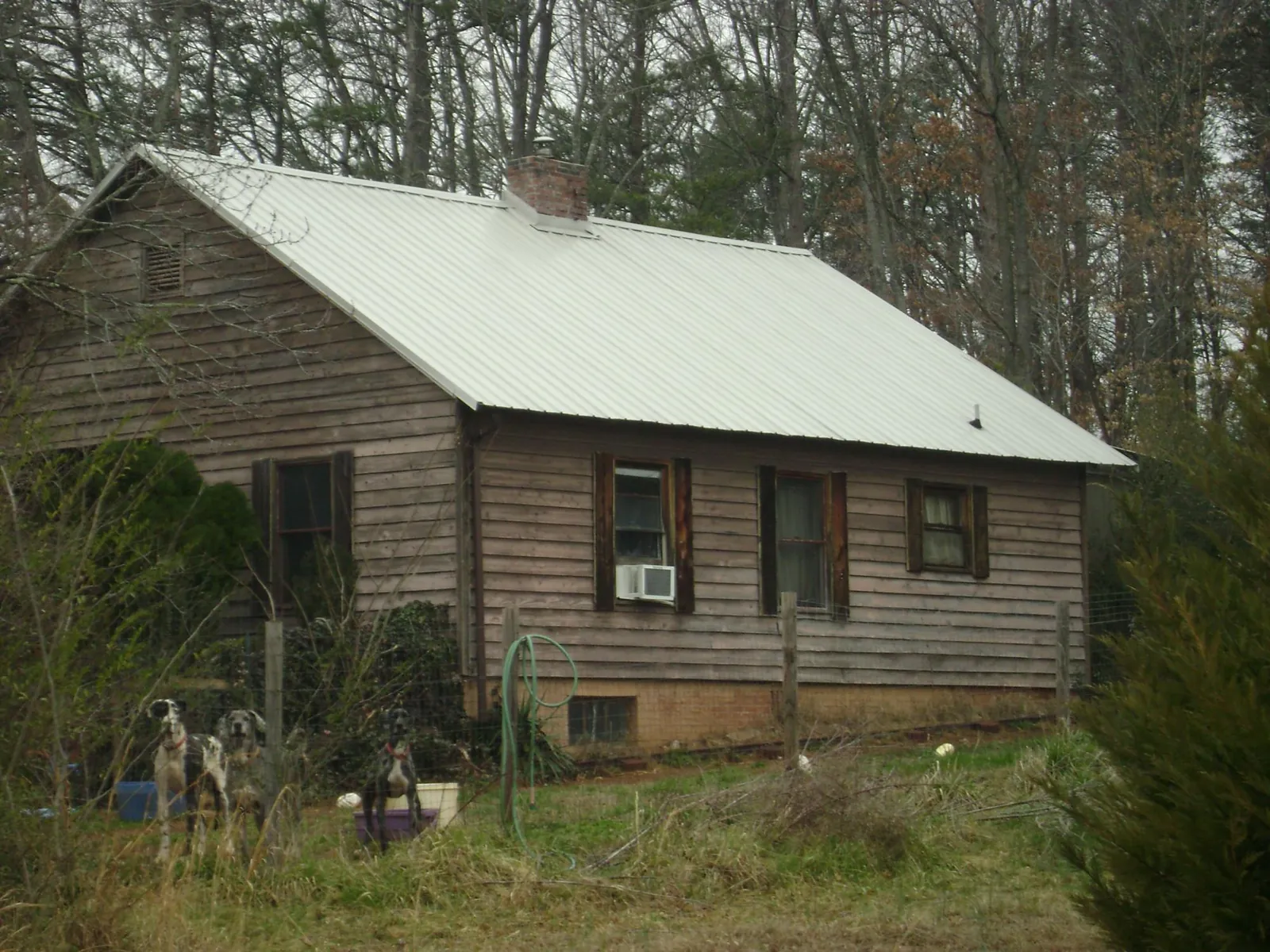 White metal roof on an old wood sided farmhouse, from a Metal Roof Installation job in Saint Regis